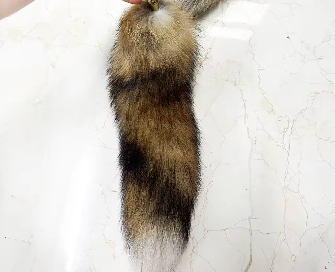 Realistic fox tail with brown and black fur on a white background
