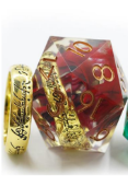 This 33mm D20 Die has a replica gold Ring in the center, swirled with red. It is pictured next to the ring to show the size of the item inside the die. 