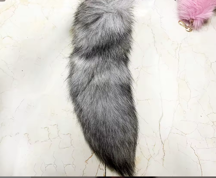 Realistic gray fox tail on a textured white surface