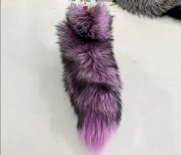 Purple and gray fur tail keychain on a white background