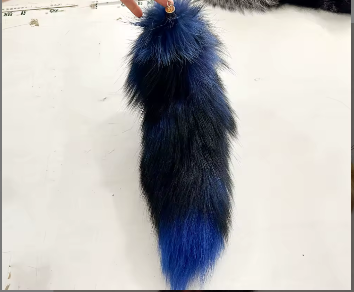 Blue and black fur tail on a white background