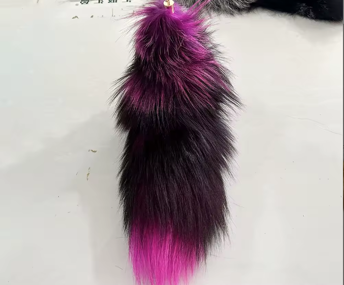 Fur tail keychain with pink and black gradient on a white background