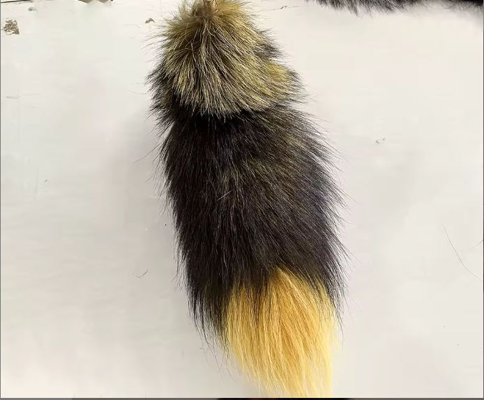 Fur tail with black, brown, and yellow gradient on a white background